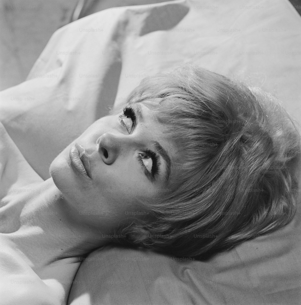 a black and white photo of a woman laying in bed