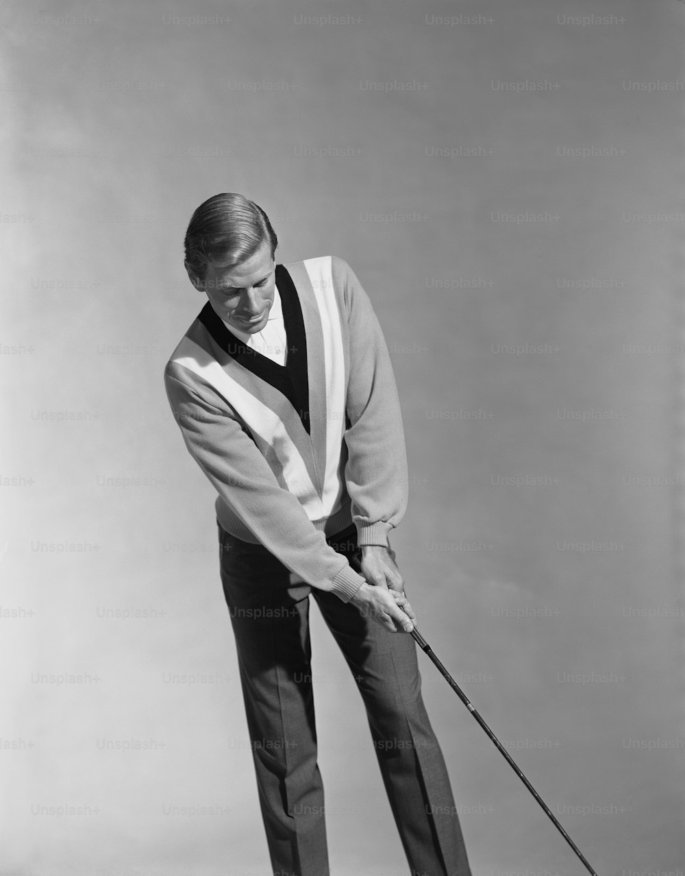 Ein Mann, der einen Golfschläger in der rechten Hand hält