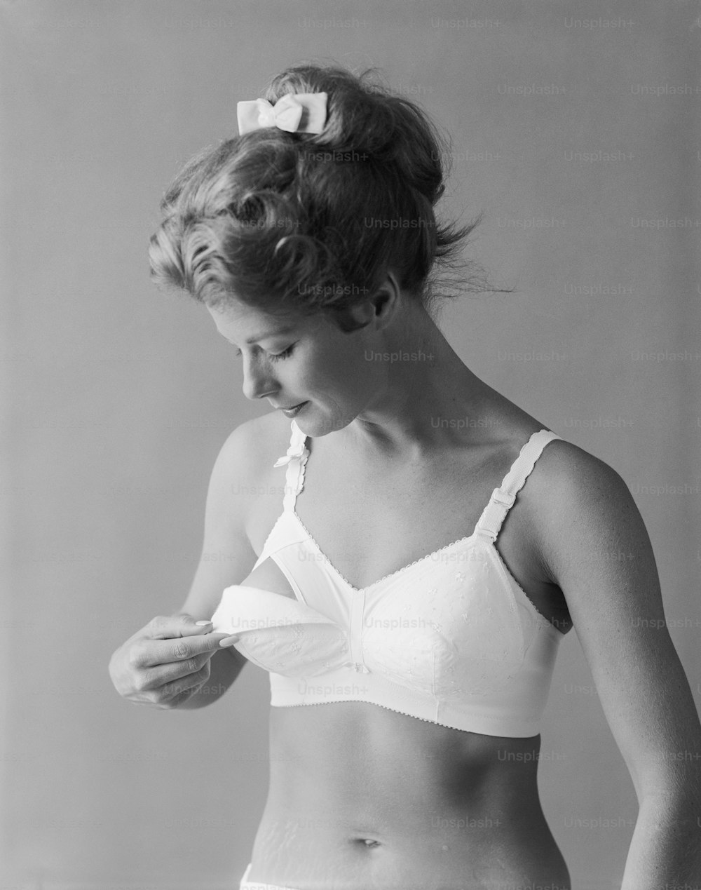 a black and white photo of a woman in a bra