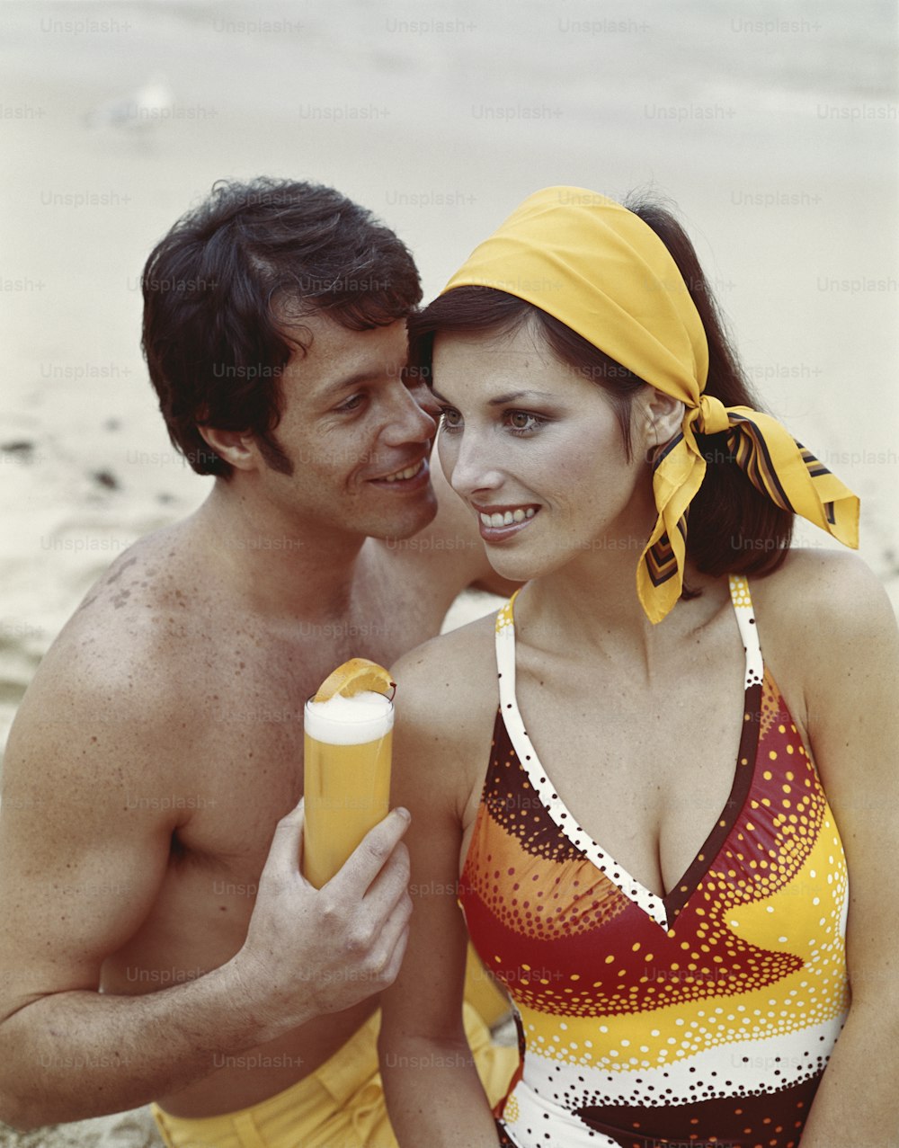 a man and a woman in bathing suits on the beach