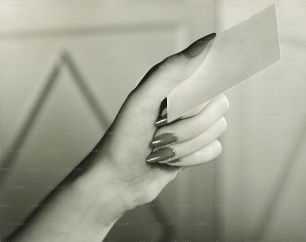 uma mulher segurando um pedaço de papel na mão