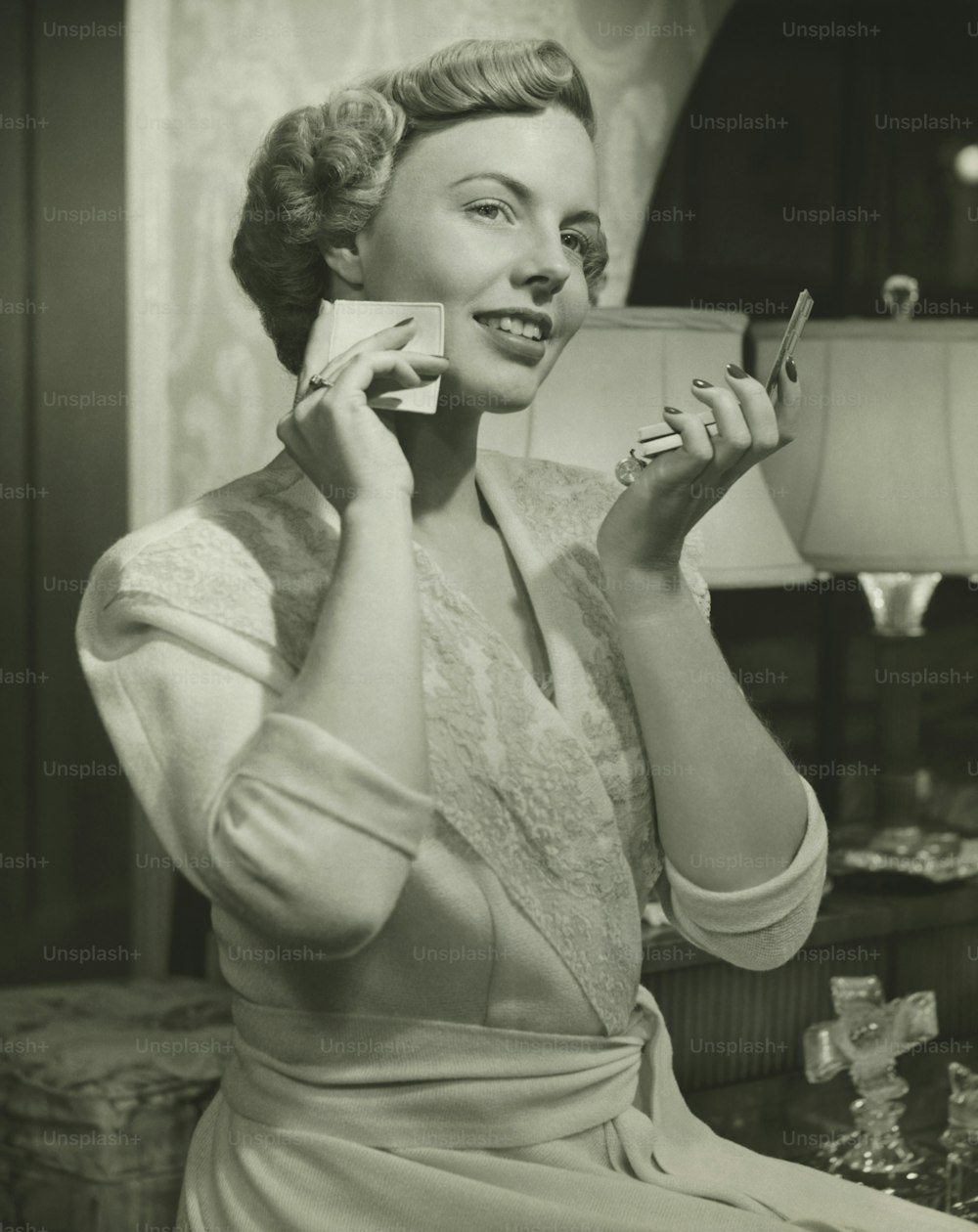 uma mulher segurando um copo e um celular