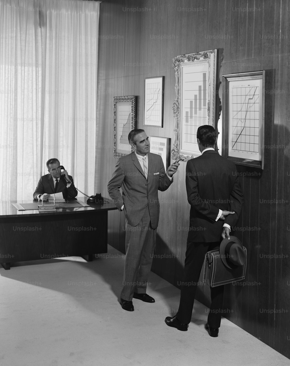 two men in suits are standing in a room