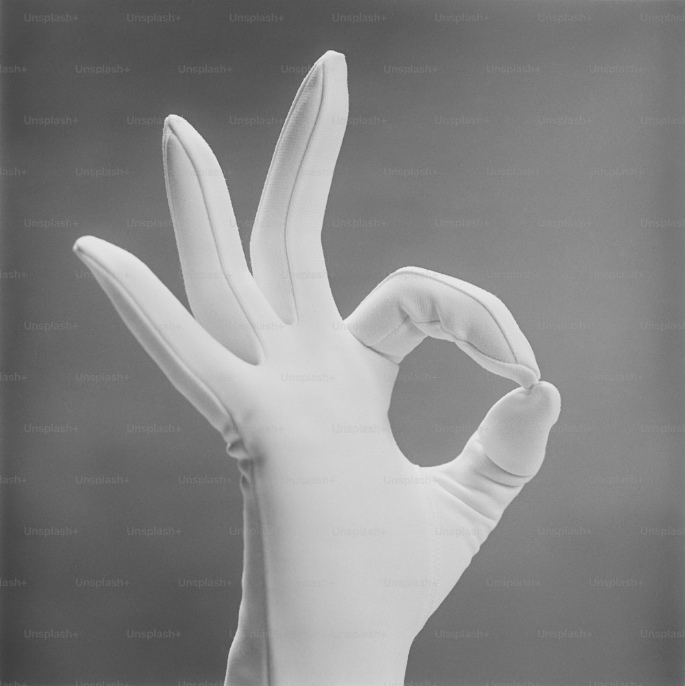 a hand with a white glove on top of it
