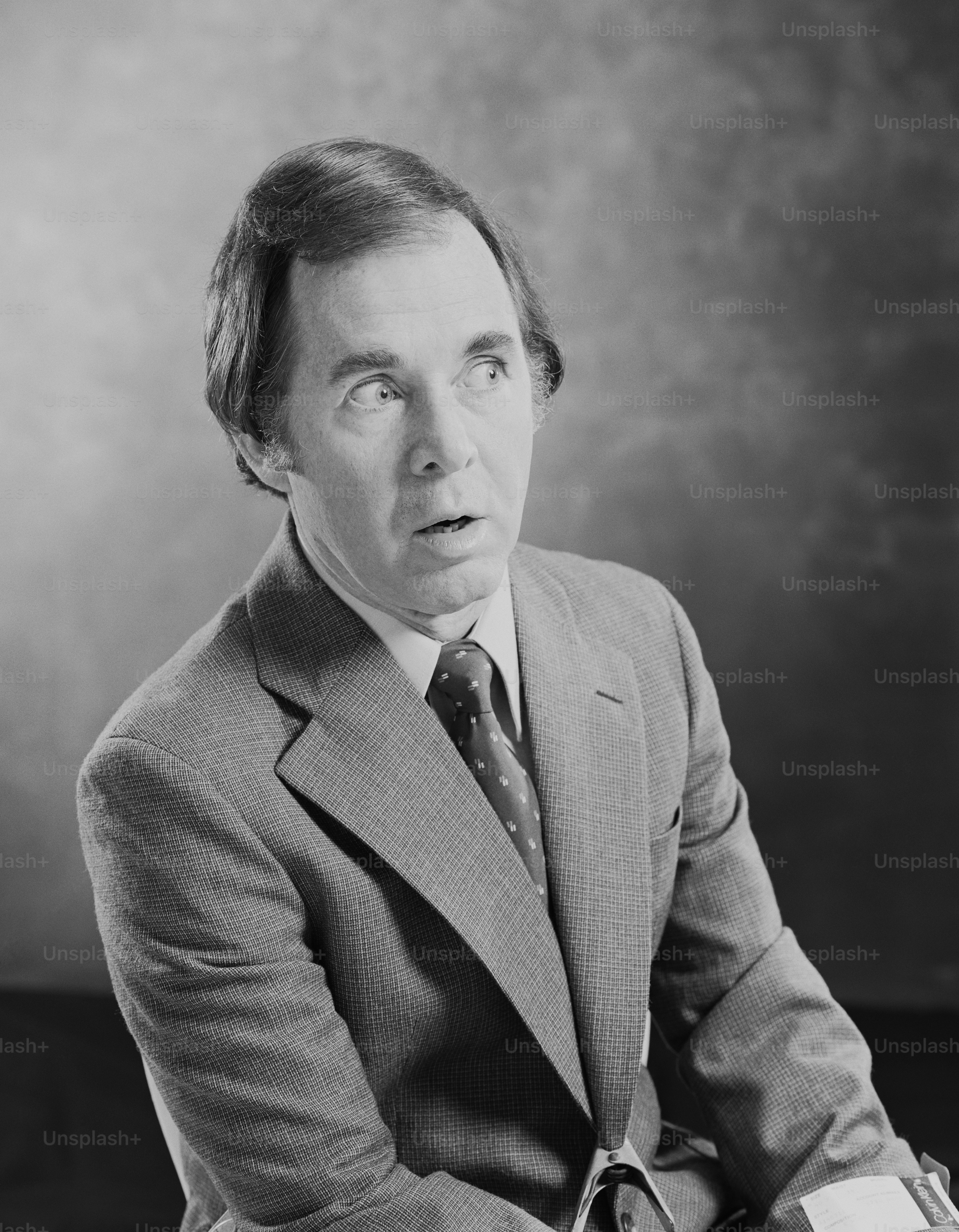 a black and white photo of a man in a suit