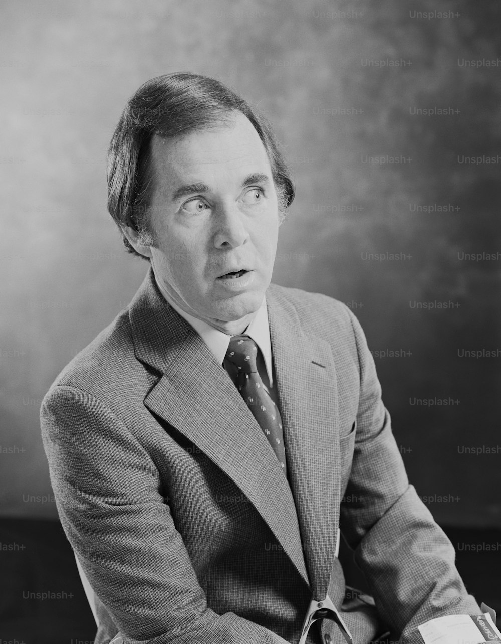 a black and white photo of a man in a suit