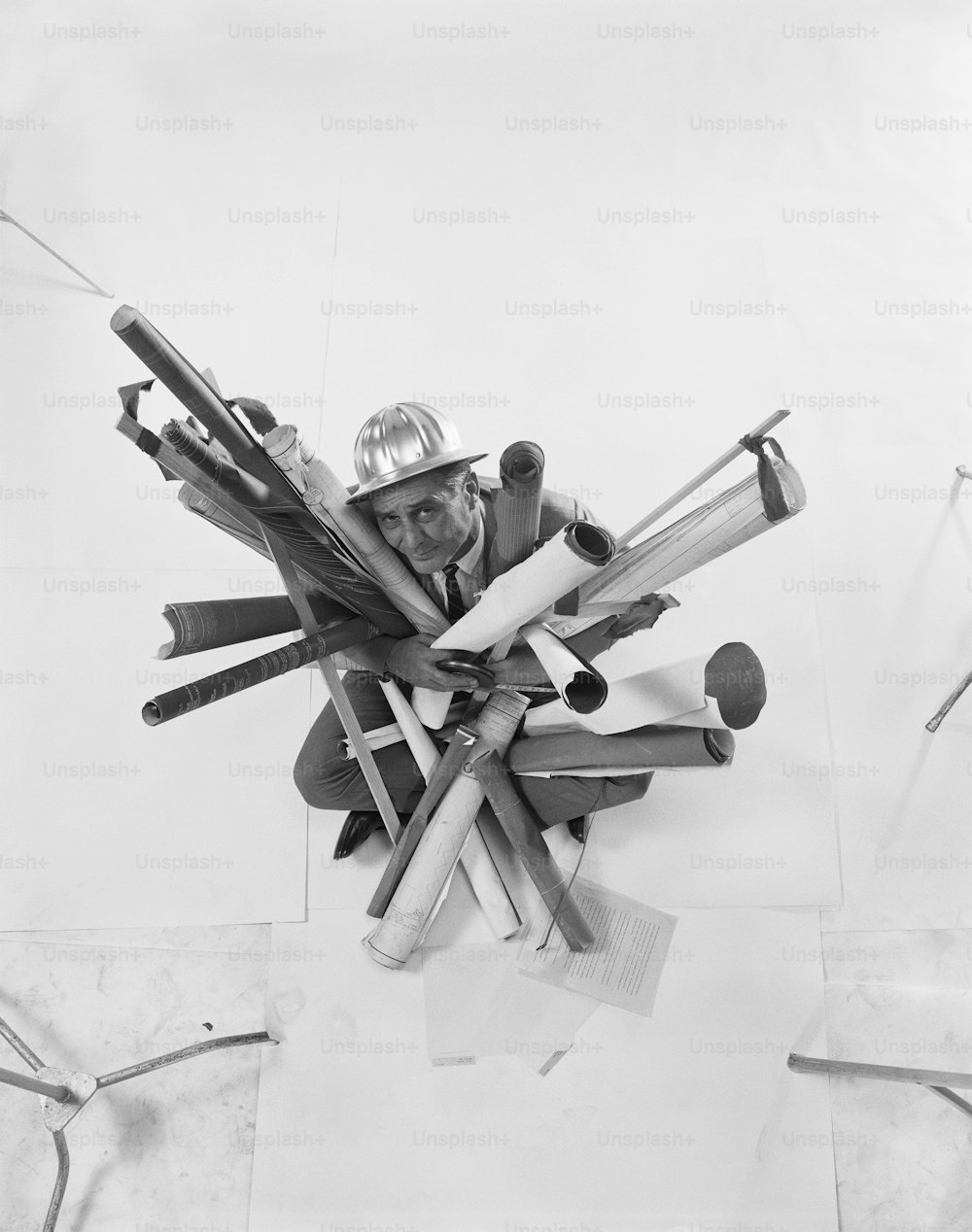 a black and white photo of a man surrounded by tools