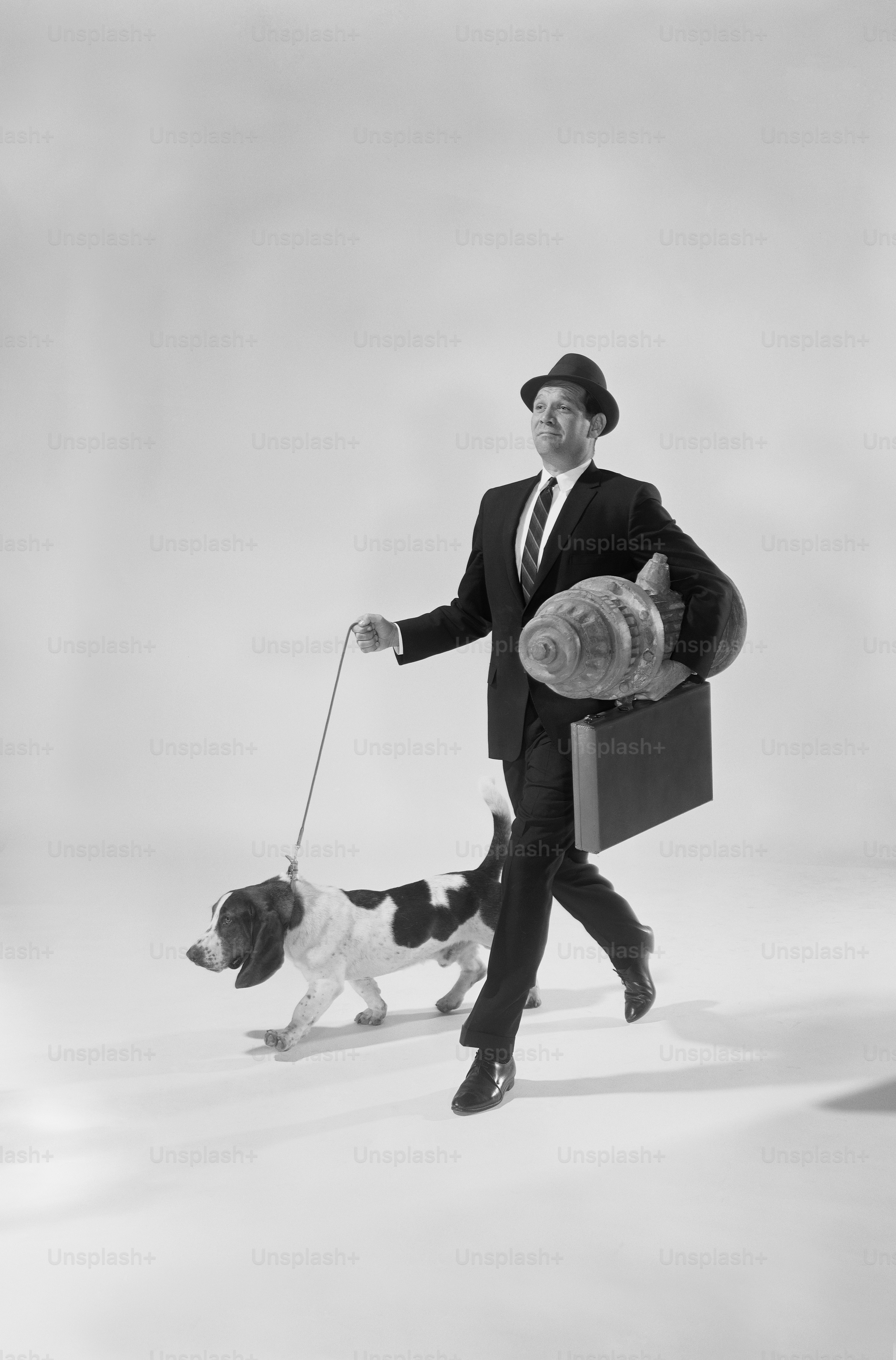 a man in a suit and tie walking a dog