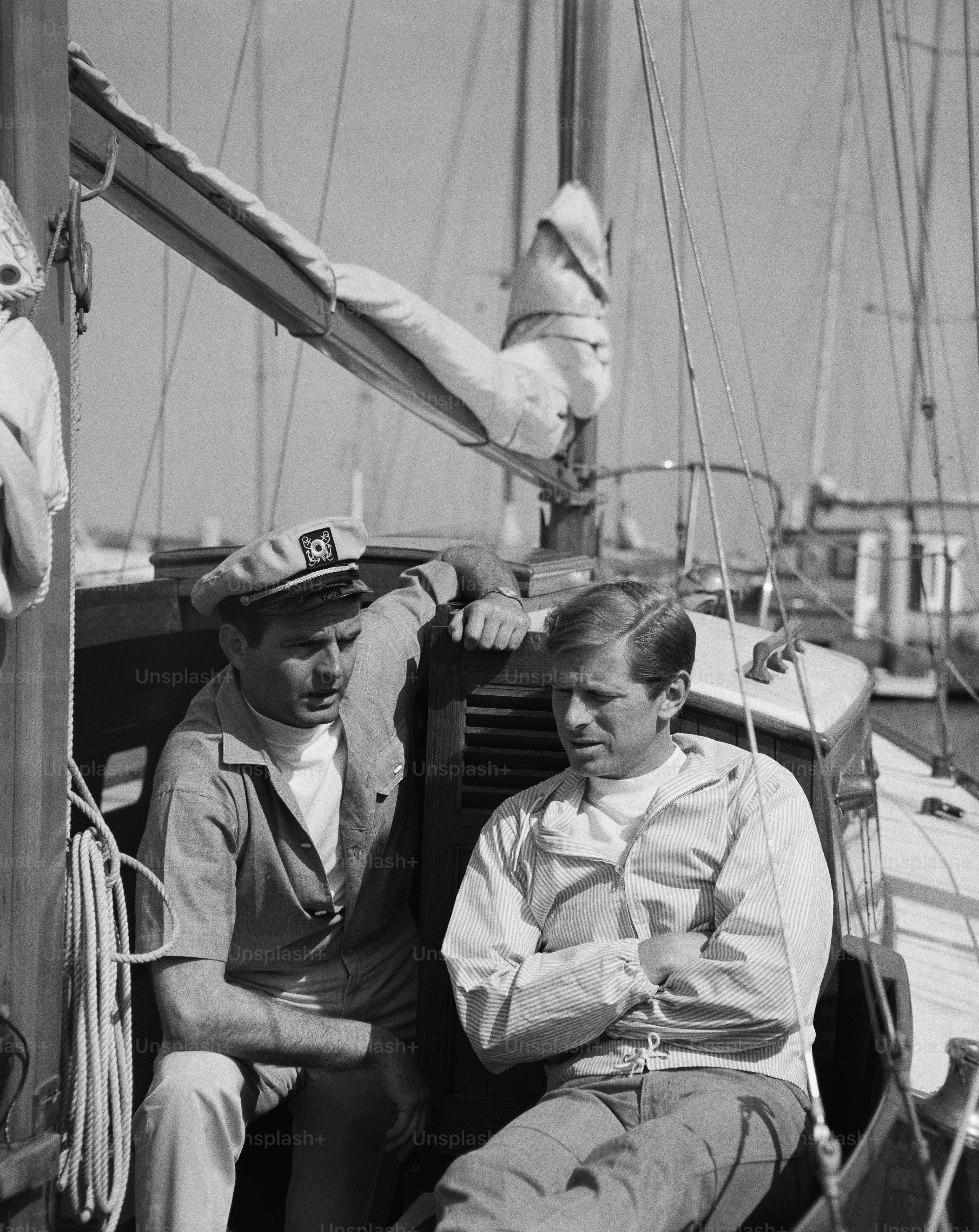 a black and white photo of two men on a boat