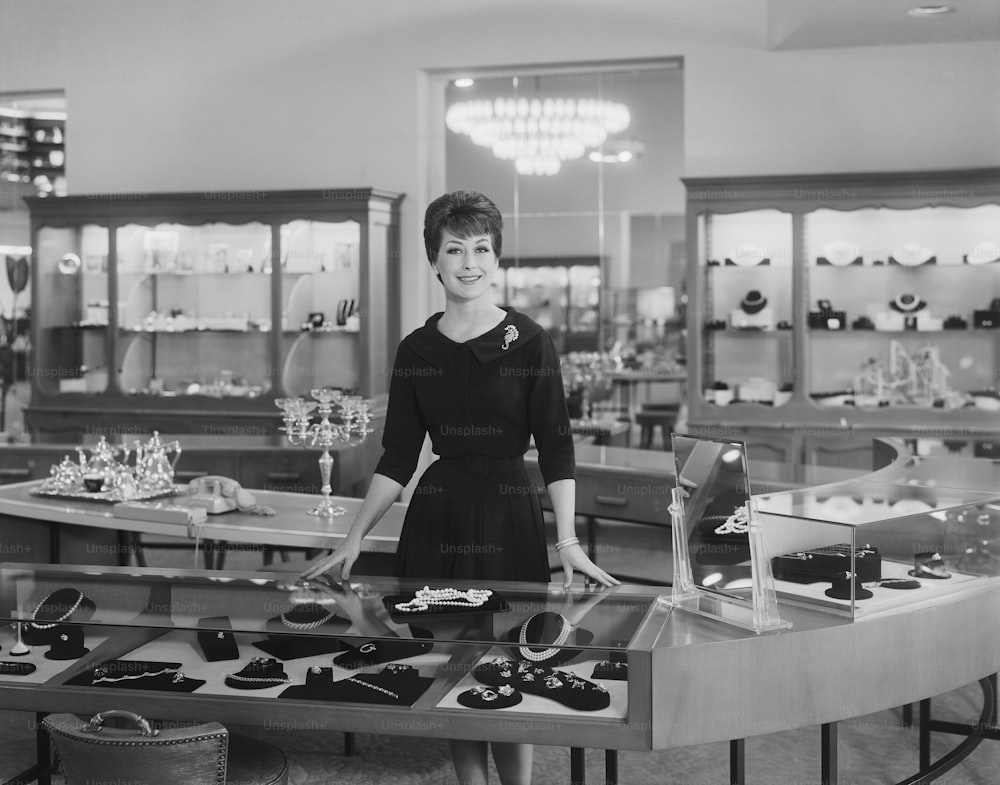 a woman standing in front of a table filled with jewelry