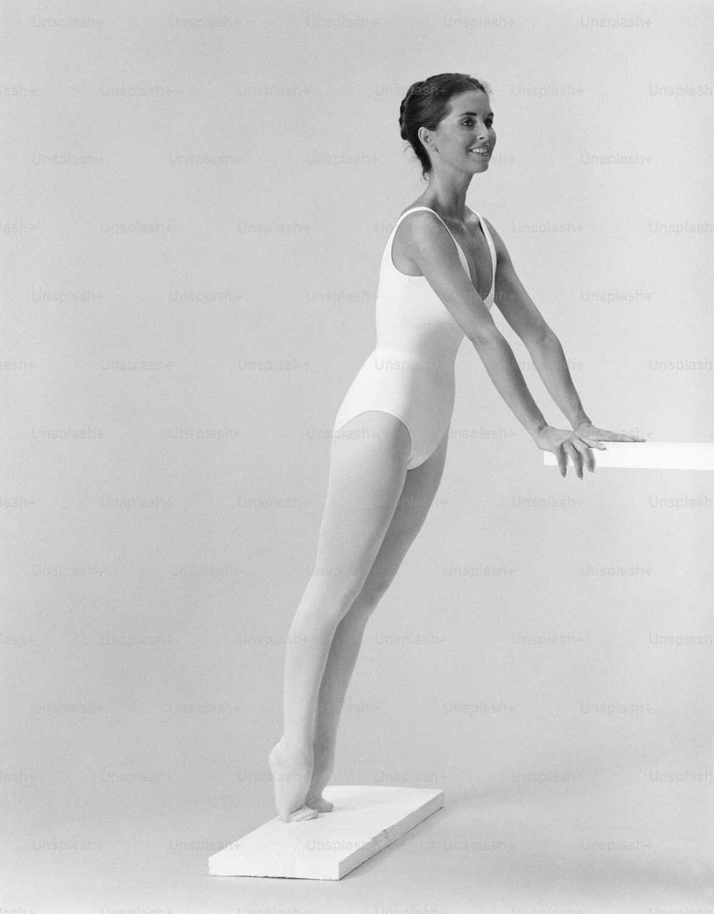 a black and white photo of a woman in a leotard
