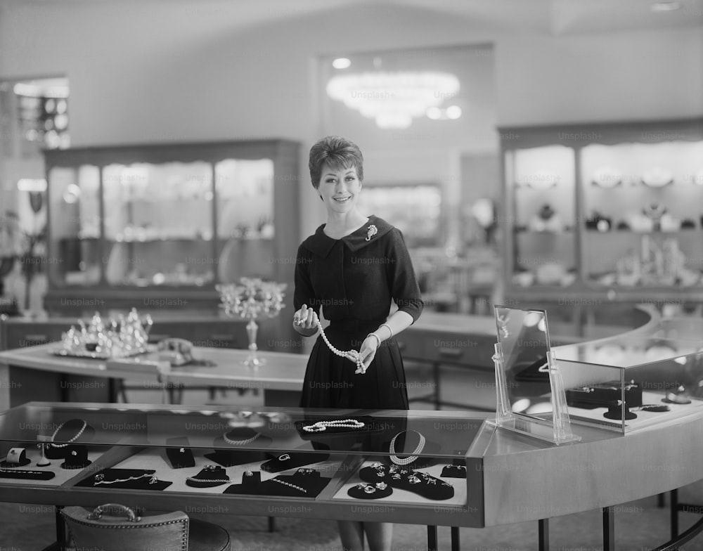 uma mulher em pé em frente a uma mesa cheia de joias