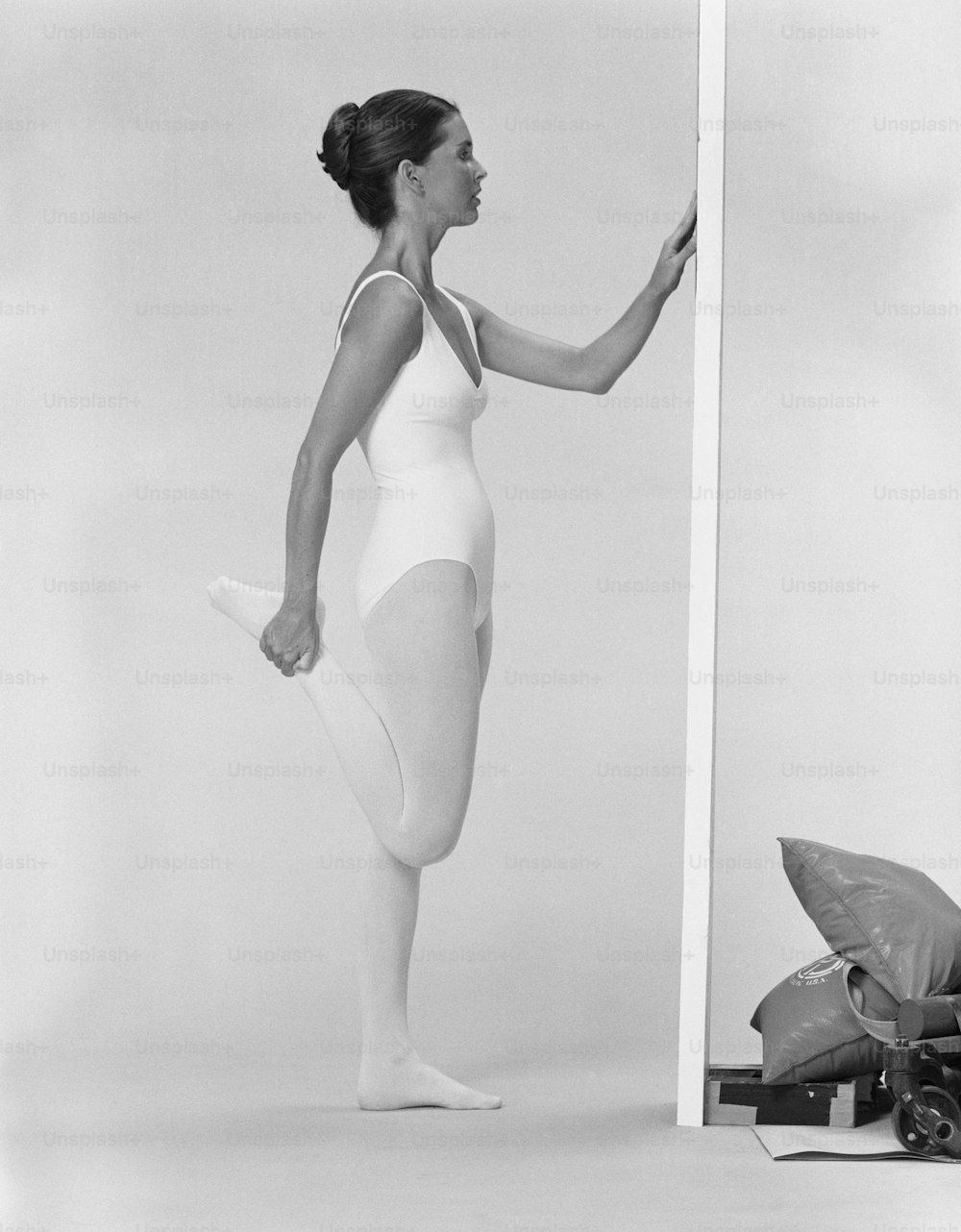 a black and white photo of a woman in a leotard