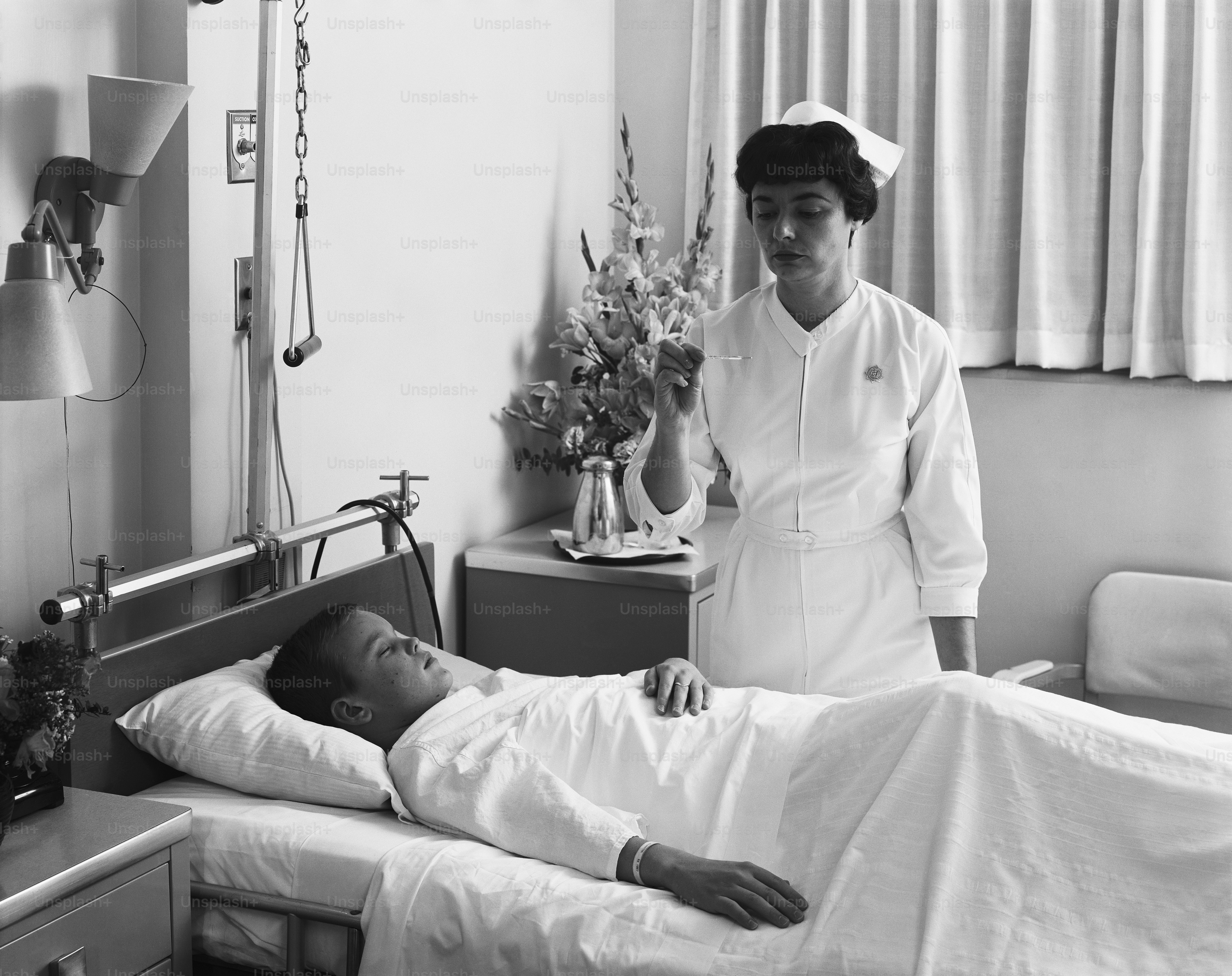 ein Schwarz-Weiß-Foto einer Krankenschwester, die sich um einen Patienten kümmert