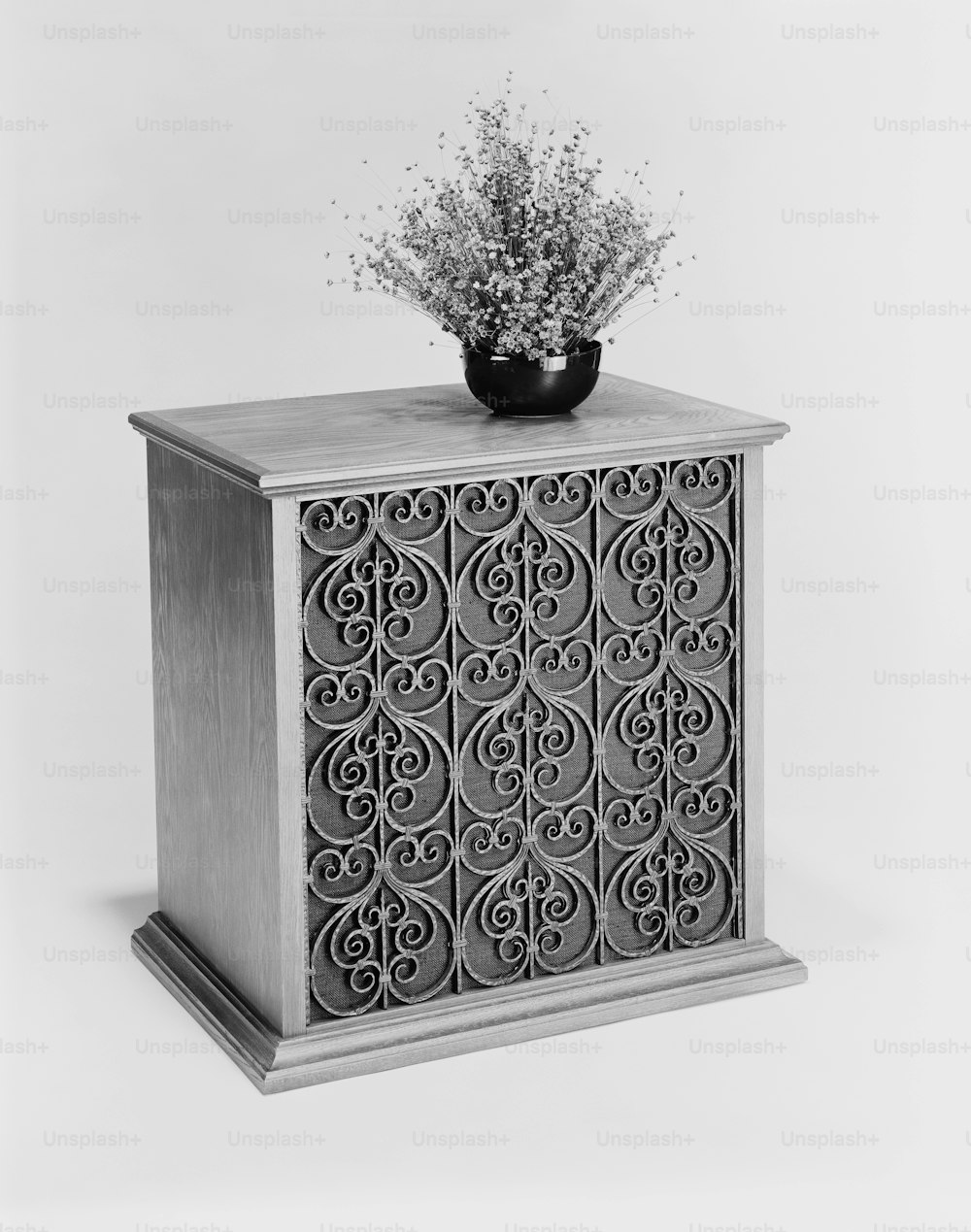 a black and white photo of a vase with flowers