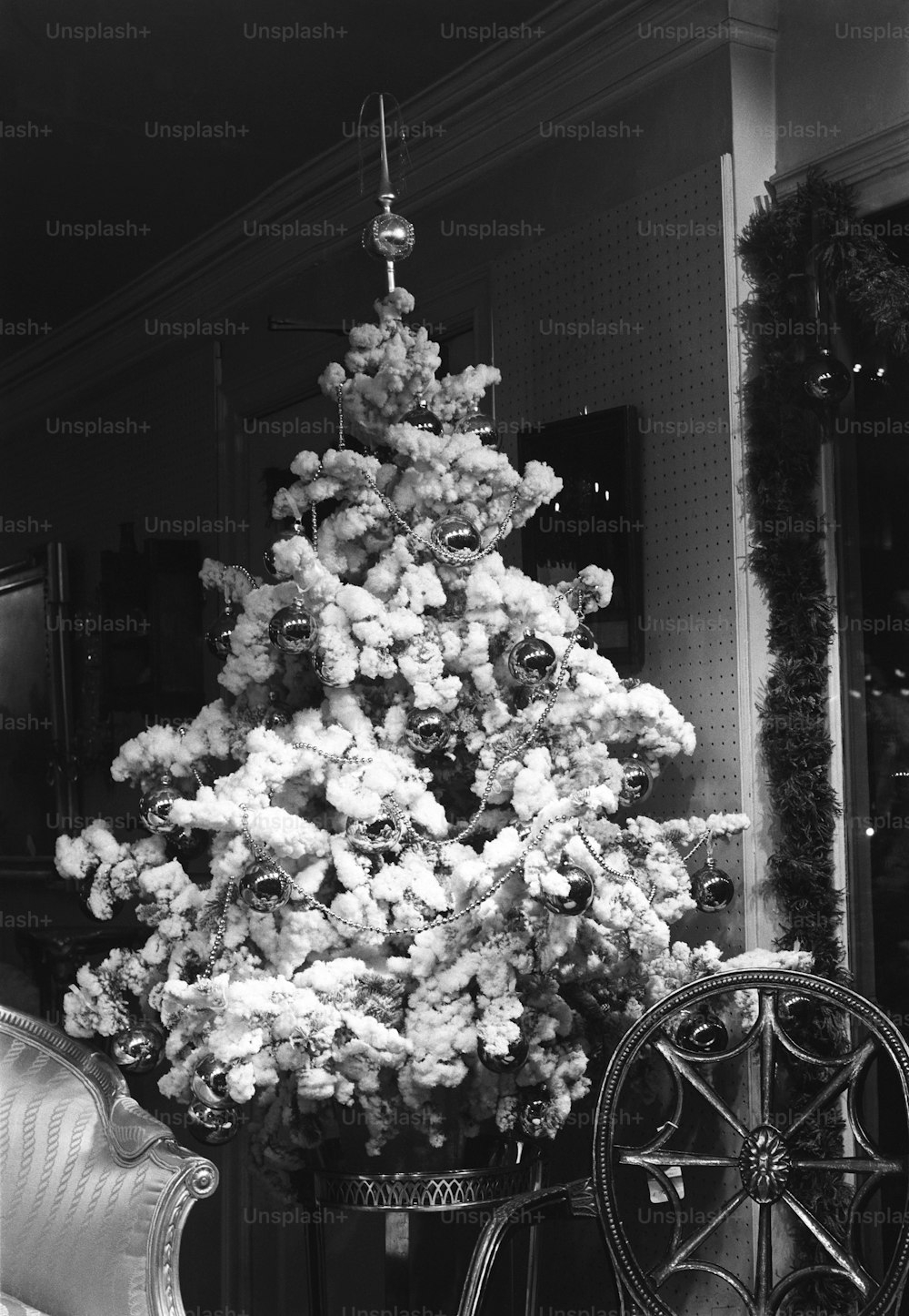 a white christmas tree sitting in a living room next to a couch