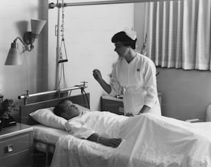Un hombre acostado en una cama de hospital junto a una mujer