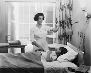 a nurse is tending to a patient in a hospital bed