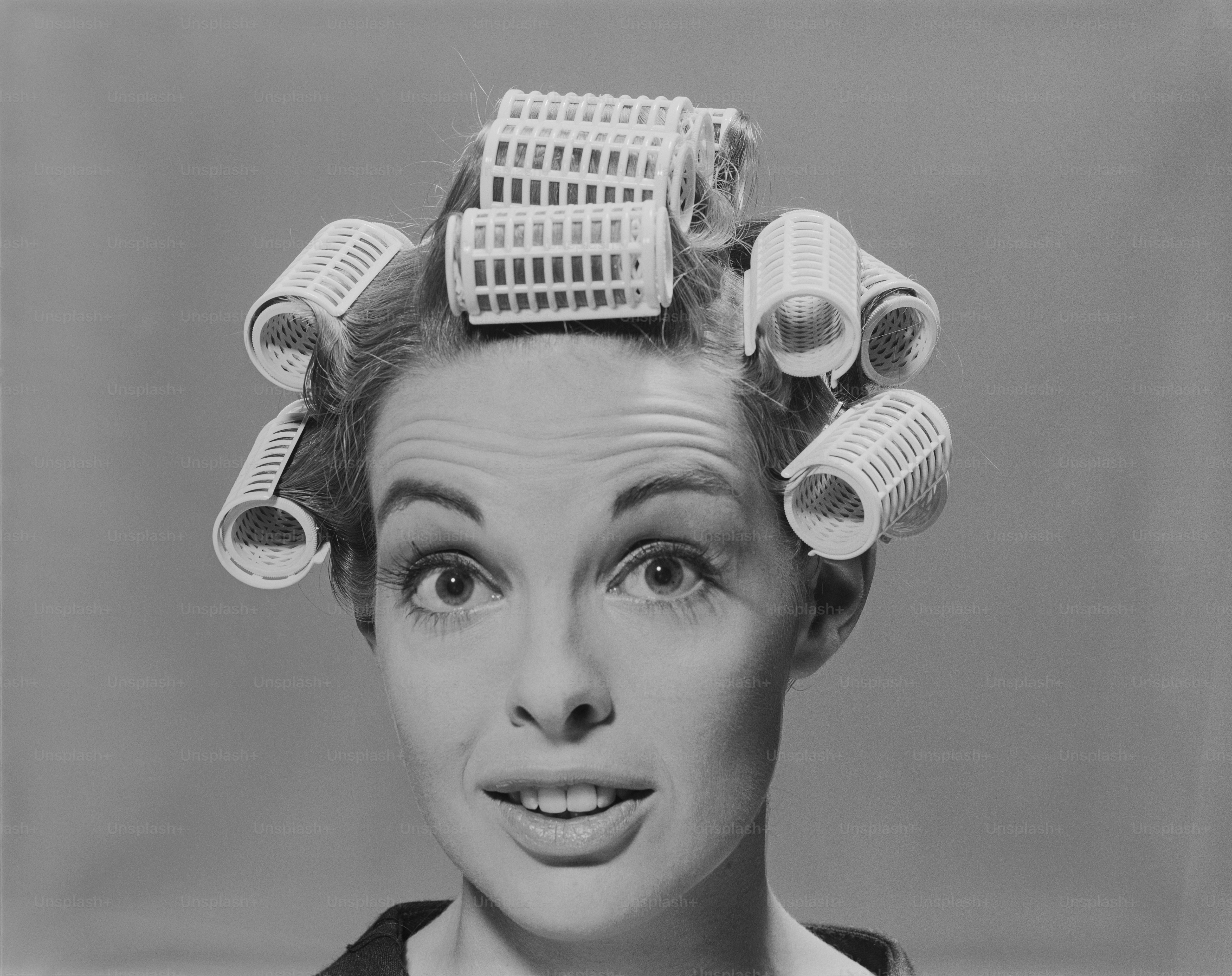 a black and white photo of a woman with hair rollers on her head