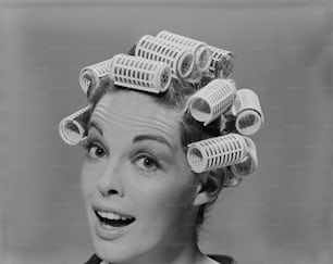 a black and white photo of a woman with curlers on her head