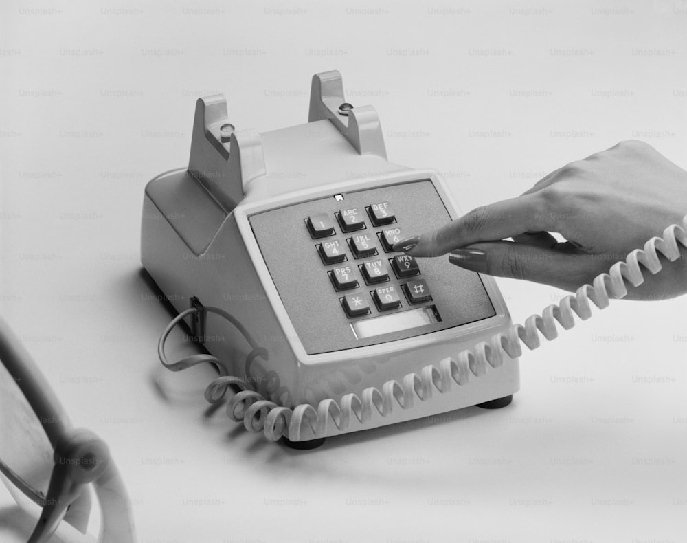 a person pressing a button on a telephone