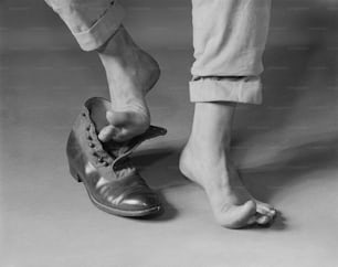 une photo en noir et blanc d’une personne attachant une chaussure