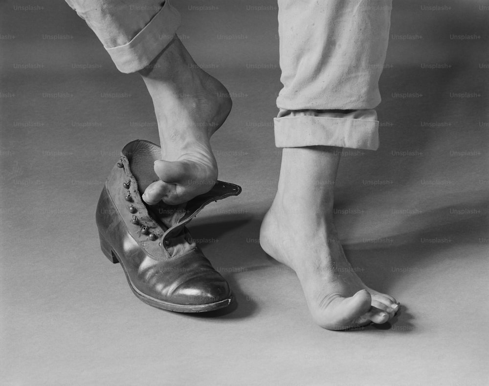 a black and white photo of a person tying a shoe