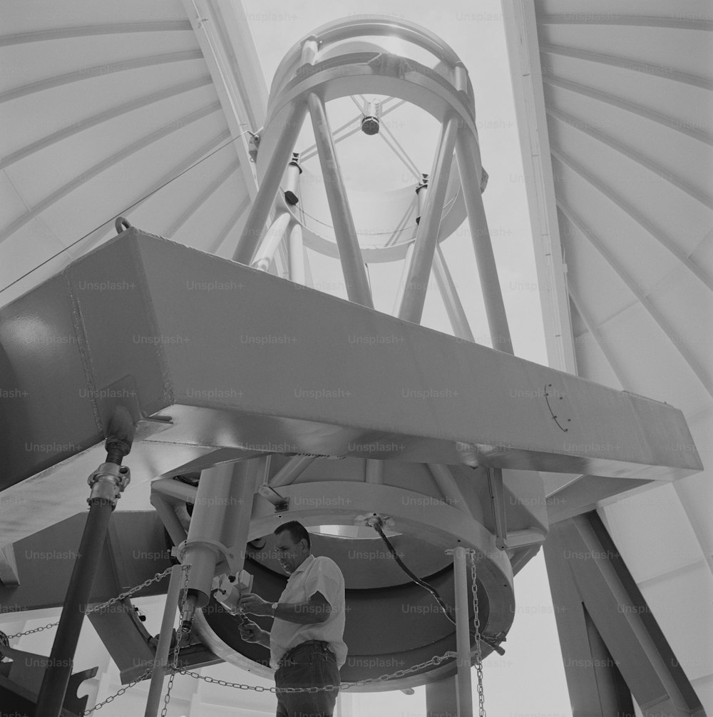 a man working on a large object in a building