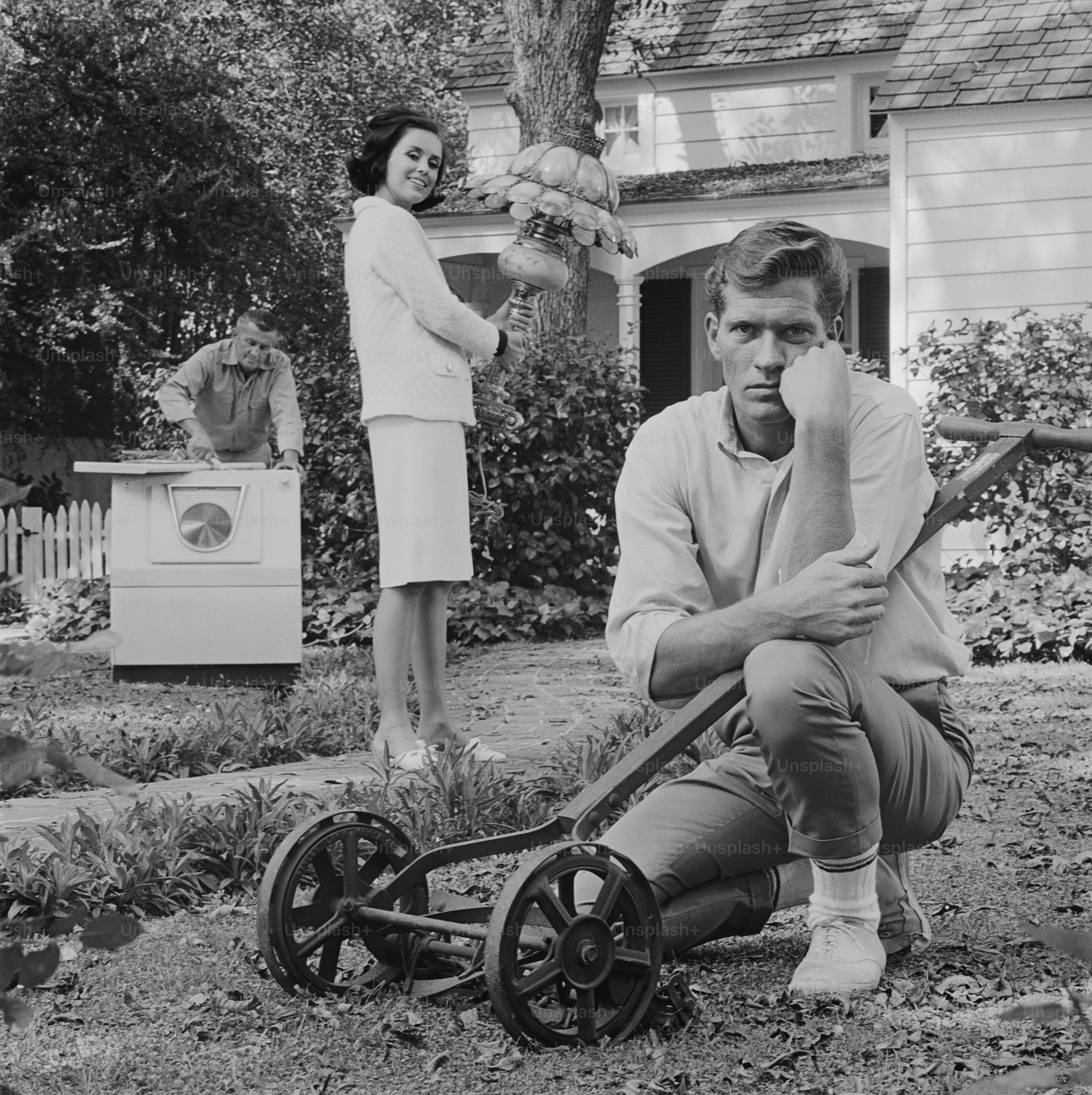 Ein Mann, der neben einer Schubkarre kniet