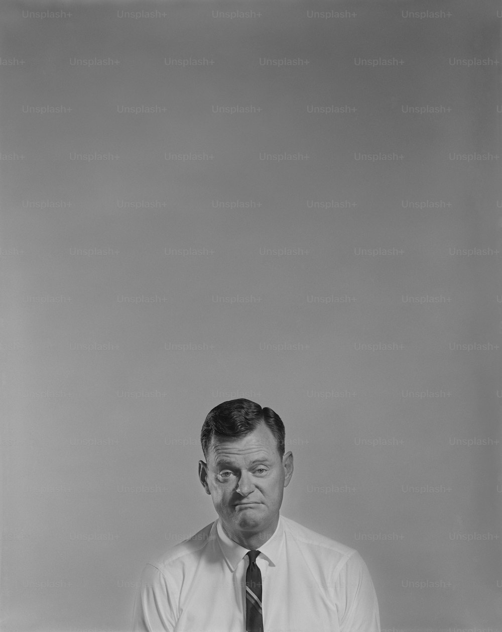 a black and white photo of a man wearing a tie