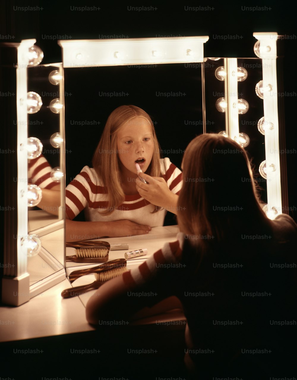 UNITED STATES - Circa 1950s:  Teenage Girl Putting Makeup On At Vanity Table.