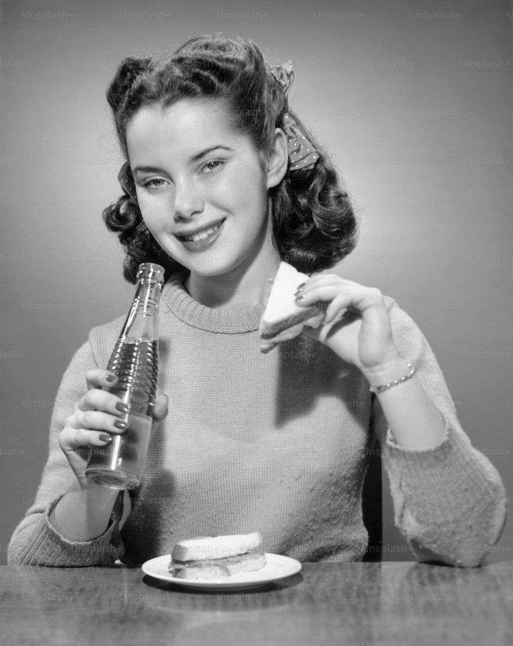 미국 - 1950년대경: 탄산음료와 샌드위치를 먹고 있는 십대 소녀.