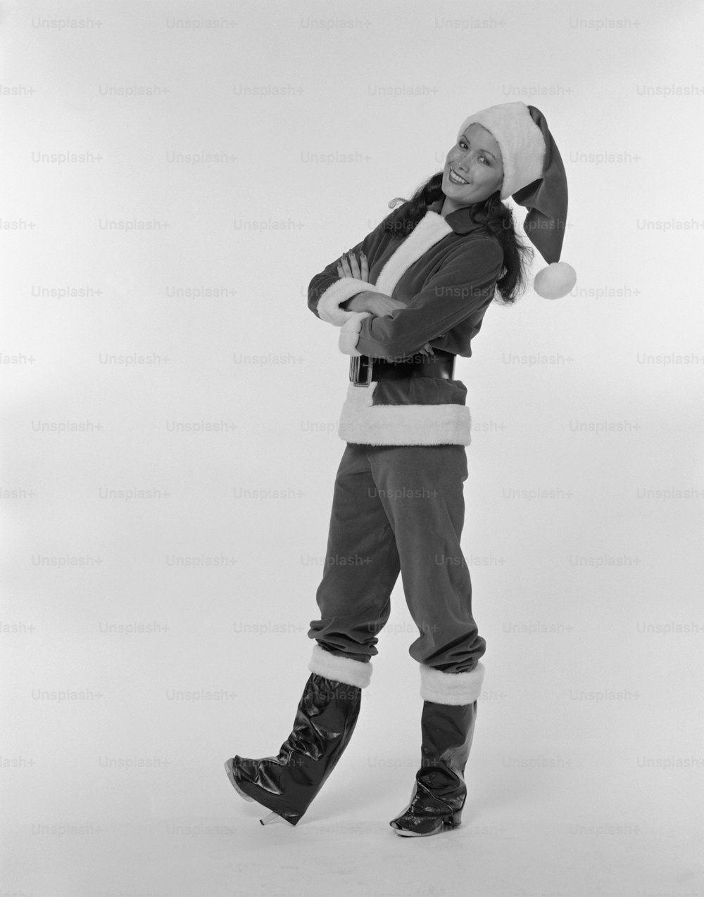 a black and white photo of a woman wearing a santa hat