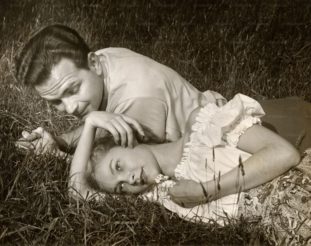 VEREINIGTE STAATEN - CIRCA 1950er Jahre: Romantisches Paar im Freien auf Gras.
