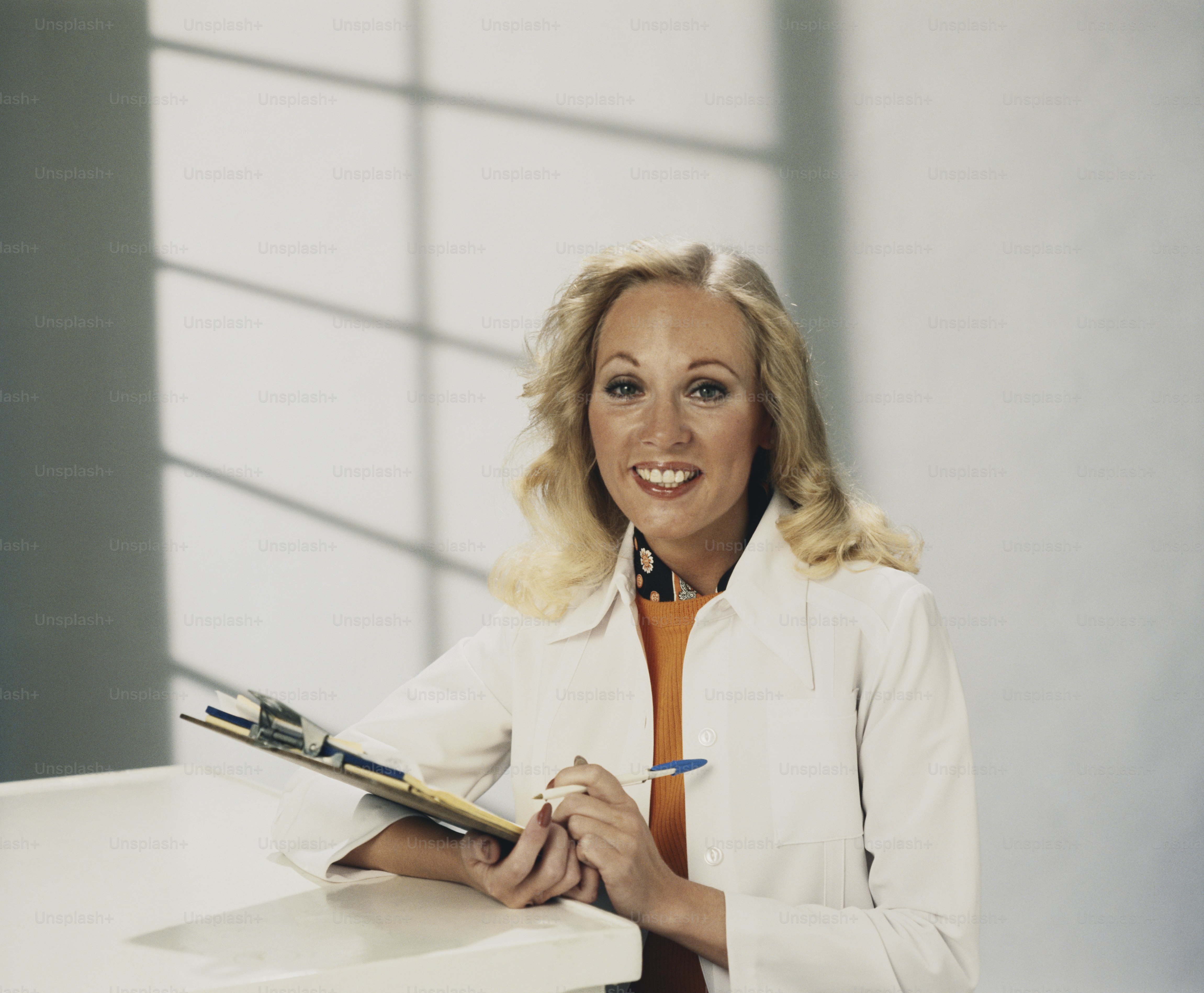 Una mujer sentada en un escritorio con un bolígrafo en la mano