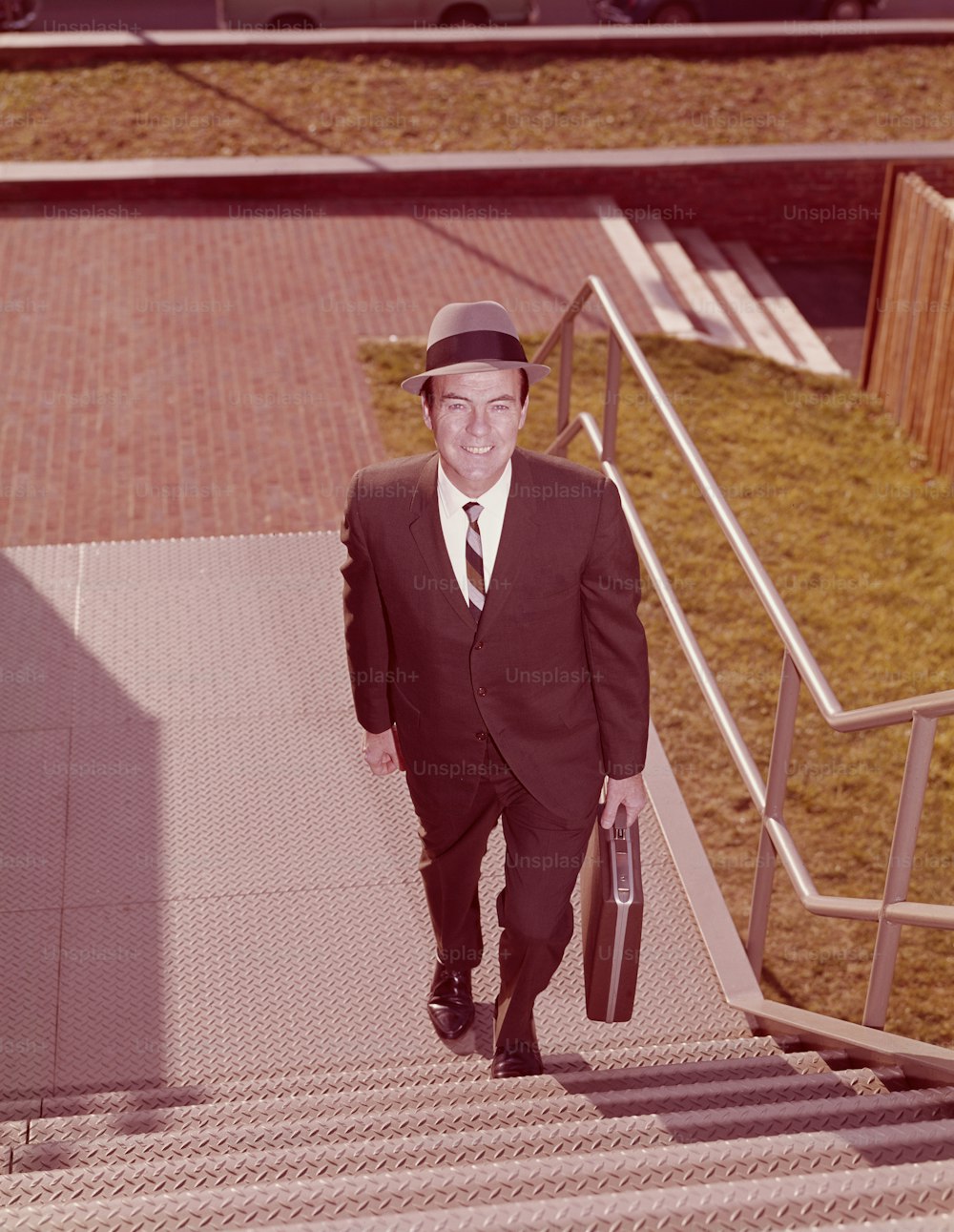 UNITED STATES - CIRCA 1960s:  Salesman climbing stairs, elevated view.