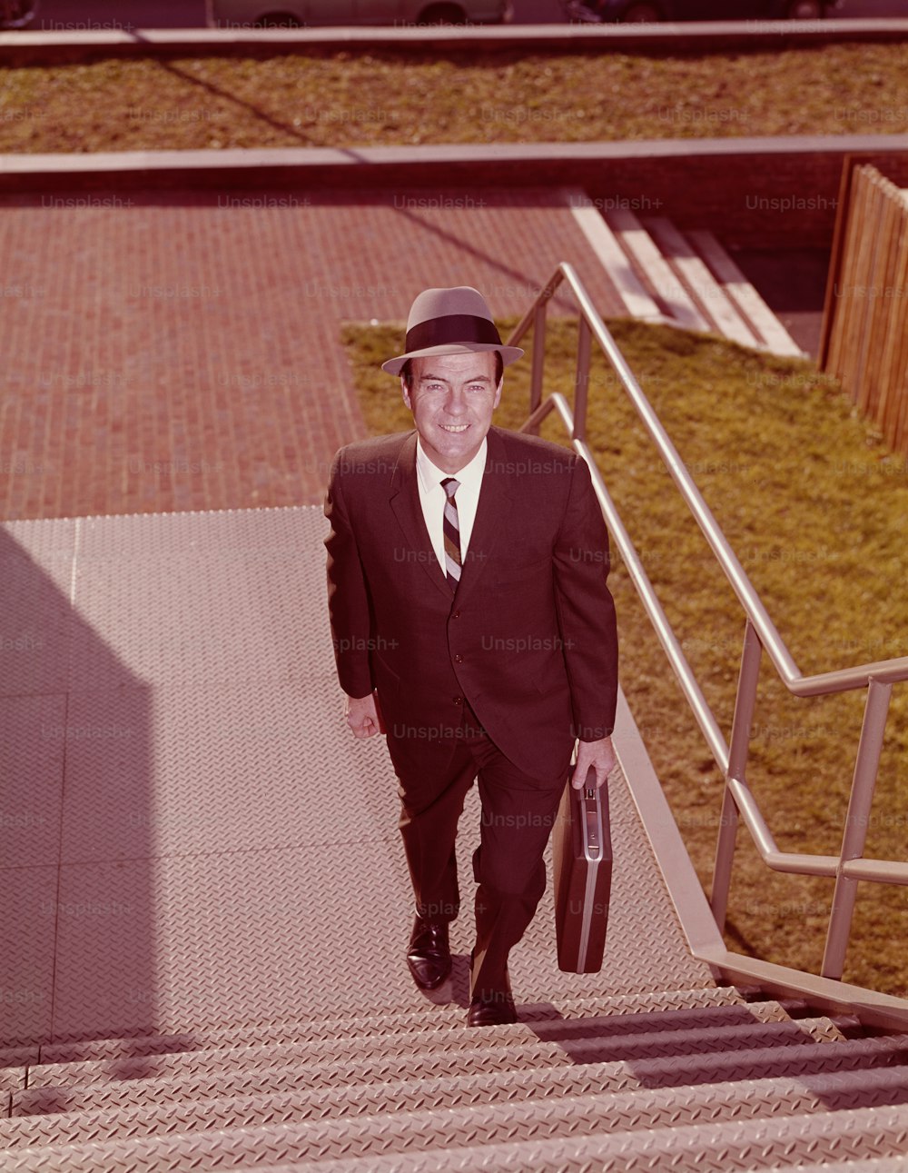 UNITED STATES - CIRCA 1960s:  Salesman climbing stairs, elevated view.