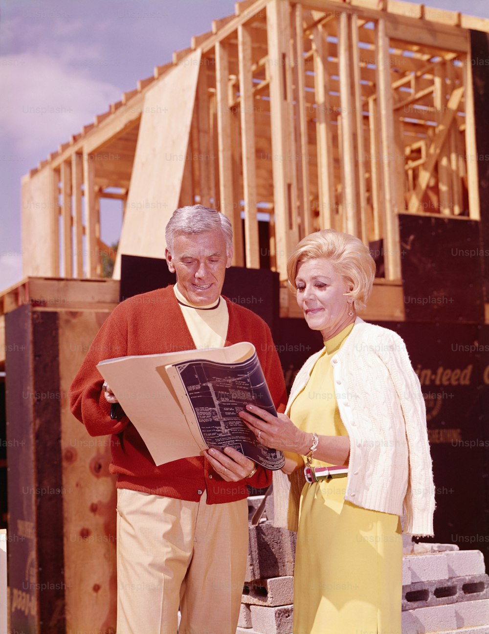 UNITED STATES - CIRCA 1960s:  Man and woman looking at blueprint.