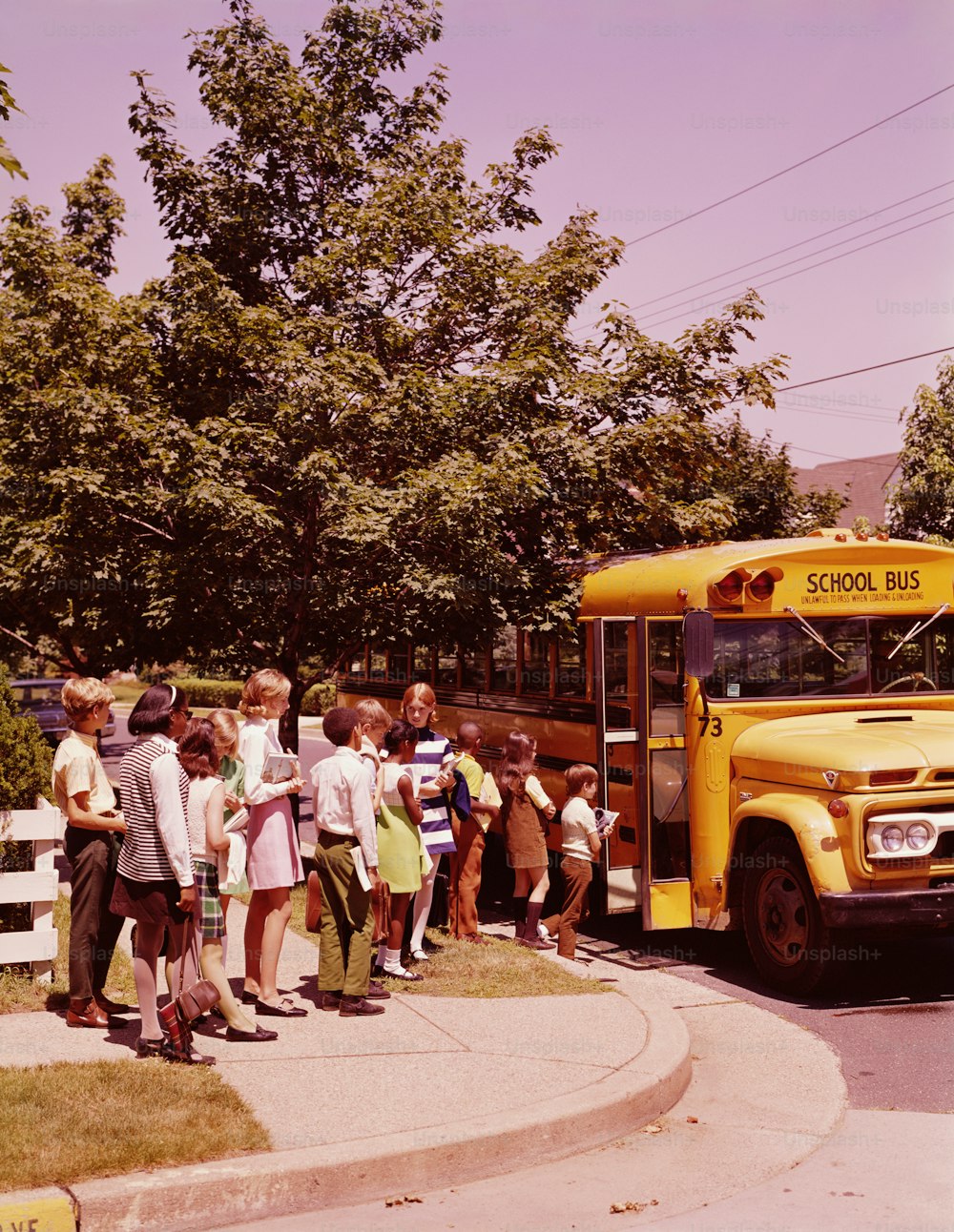 UNITED STATES - CIRCA 1970s:  Students in line, waiting to board school bus.