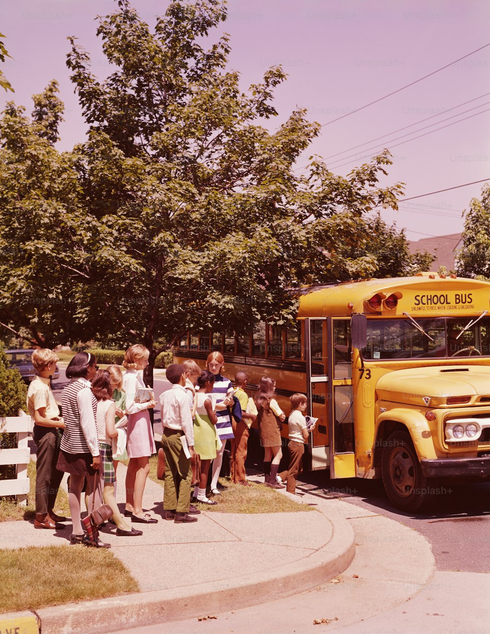 VEREINIGTE STAATEN - CIRCA 1970er Jahre: Schüler stehen Schlange, warten darauf, in den Schulbus zu steigen.