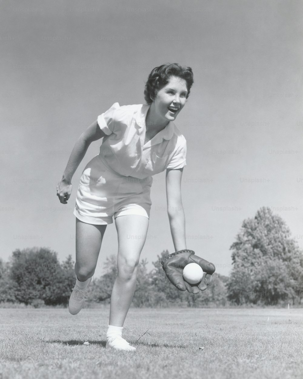 VEREINIGTE STAATEN - CIRCA 1950er Jahre: Junge Frau fängt Baseball in Handschuhen.