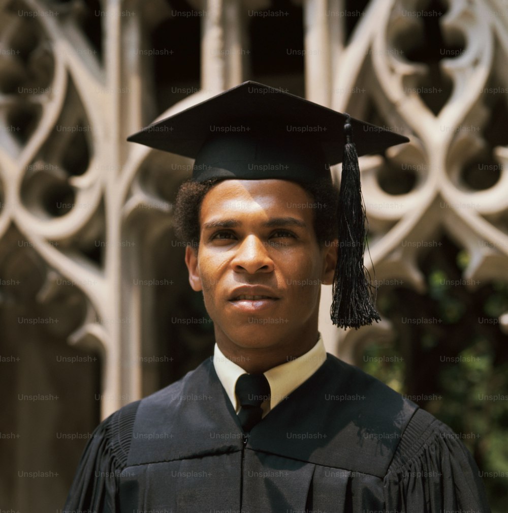 UNITED STATES - CIRCA 1970s:  Teenage student wearing robes and mortarboard at graduation.