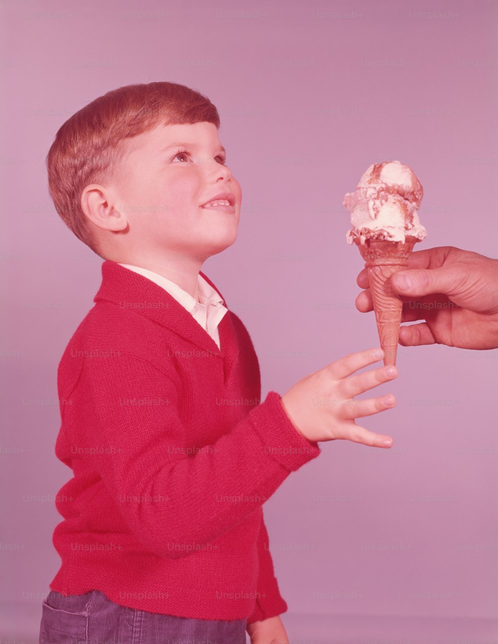 VEREINIGTE STAATEN - CIRCA 1950er Jahre: Mann hält dem Jungen Eis hin.