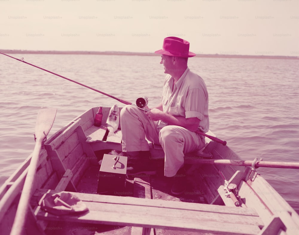 UNITED STATES - CIRCA 1950s:  Man sitting in rowing boat, fishing.