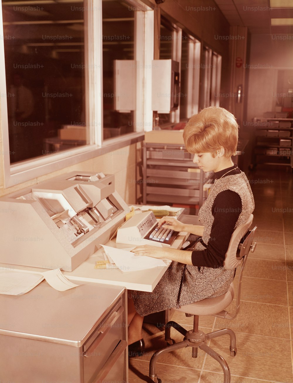 ESTADOS UNIDOS - POR VOLTA DE 1970: Mulher sentada ao teclado.