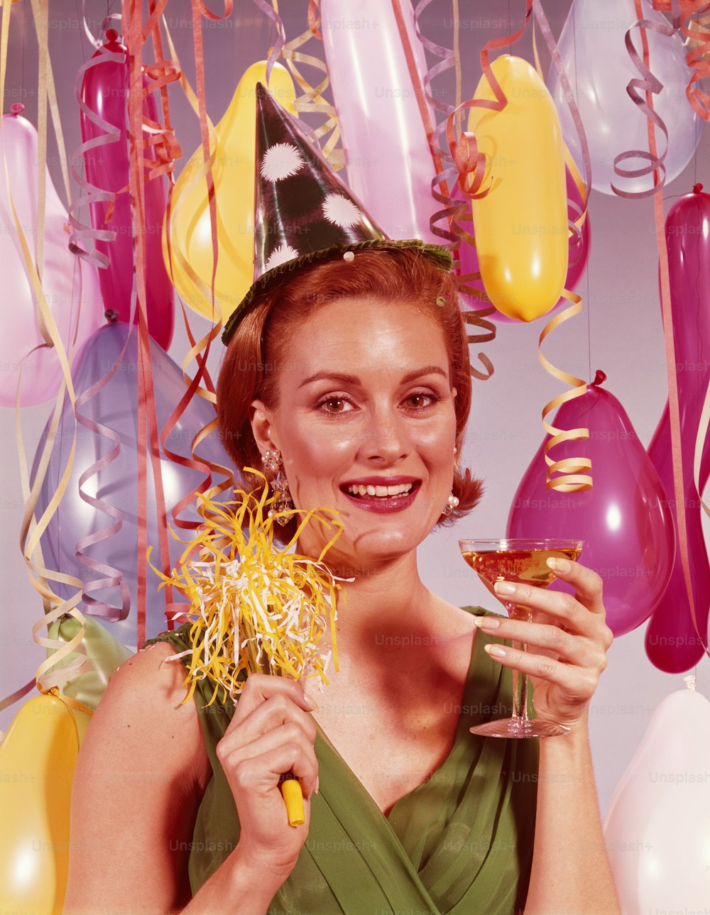 ESTADOS UNIDOS - POR VOLTA DE 1960: Mulher usando chapéu de festa de papel, segurando taça de champanhe.