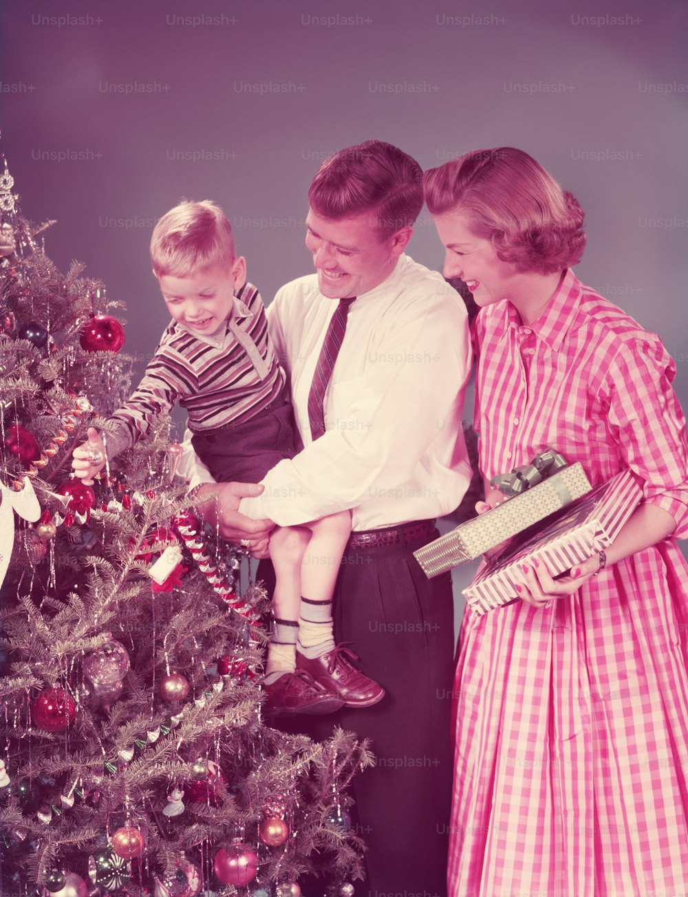 VEREINIGTE STAATEN - CIRCA 1950er Jahre: Familie zu Weihnachten, Mutter mit Geschenken, Vater mit Sohn.