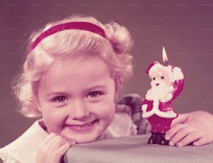 アメリカ合衆国 - 1950年代頃:父のクリスマスキャンドルを穴あける少女、笑顔、肖像画。