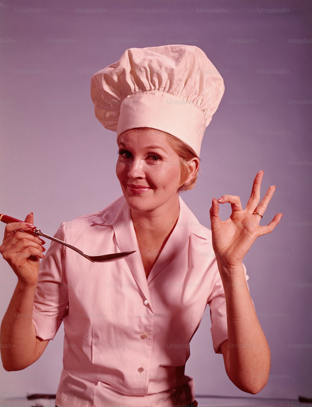 UNITED STATES - CIRCA 1960s:  Female chef smiling and gesturing 'ok' sign.
