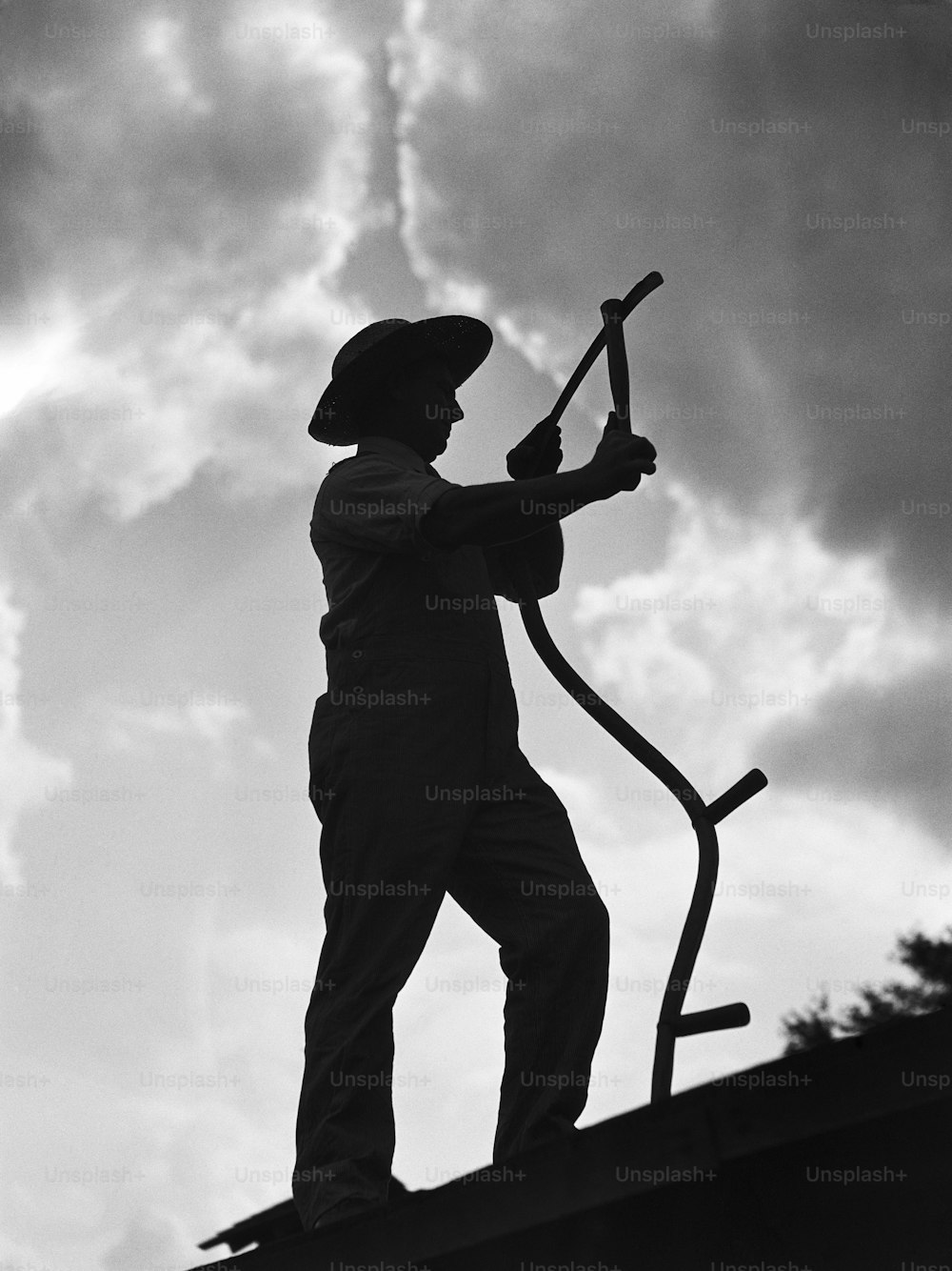 UNITED STATES - CIRCA 1930s:  Silhouette of farmer in straw hat, holding sickle.